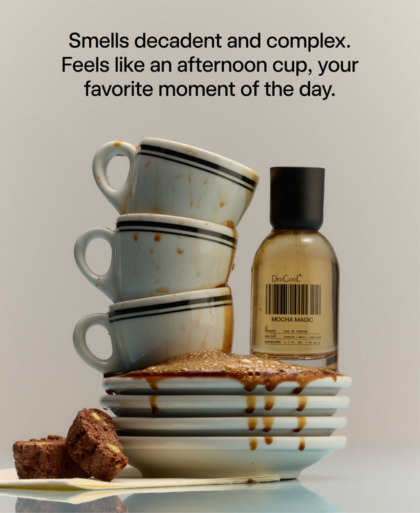 A perfume bottle labeled 'DedCool MOCHA MAGIC' stands next to a stack of stained ceramic mugs on a stack of plates with coffee spilling over with text at the top describing the scent.