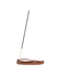 A single incense stick stands upright in a curved, polished brown wooden holder on a plain white background.